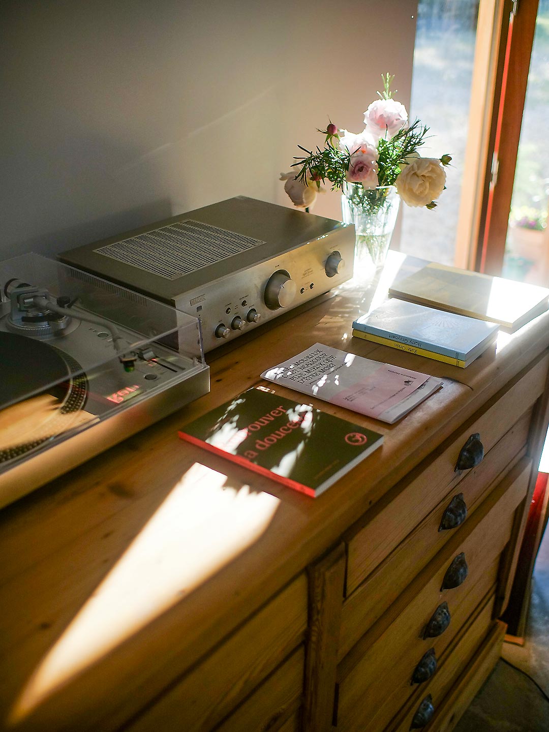 Détail de la commode avec platine vinyle et bouquet de roses dans le séjour